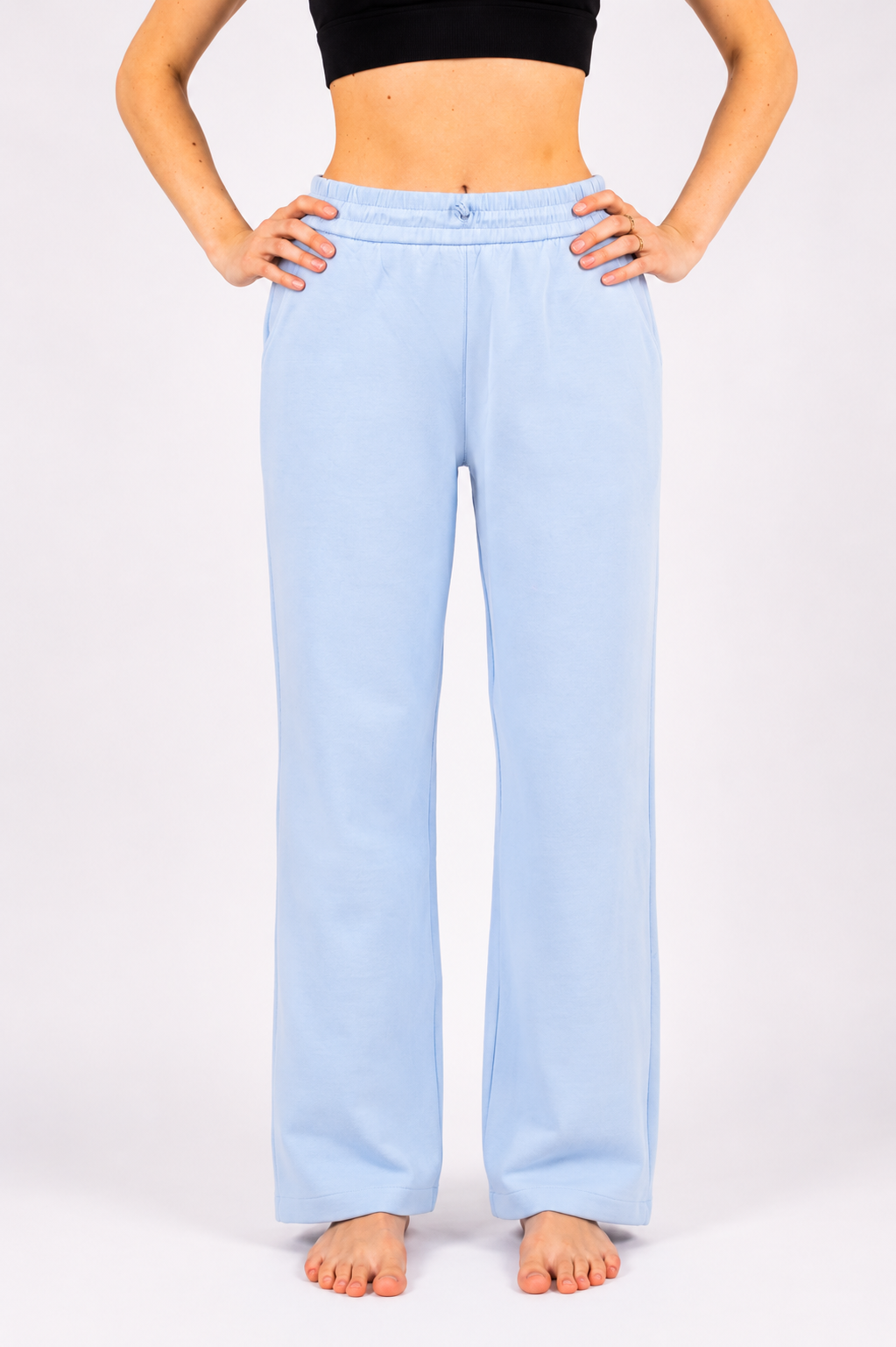 Light blue lounge pants worn by a person on a white background