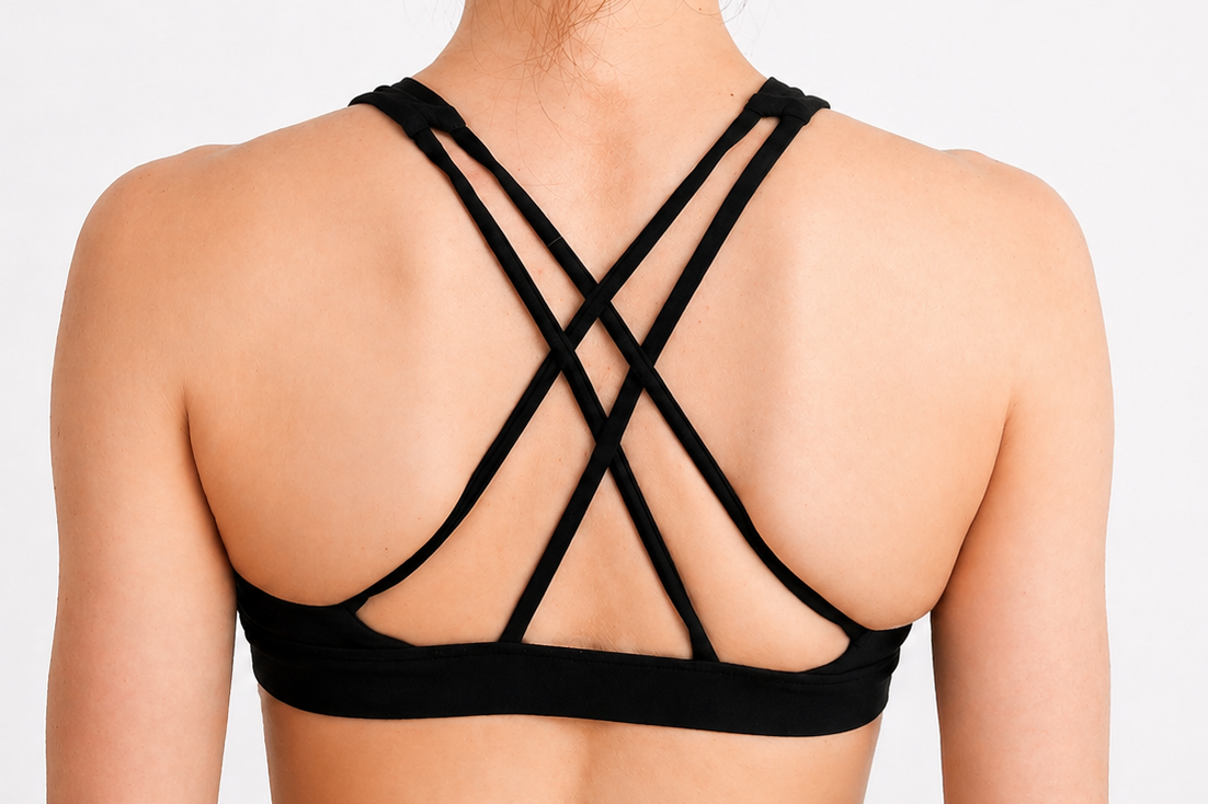 Black strappy top worn by a person on a light gray background
