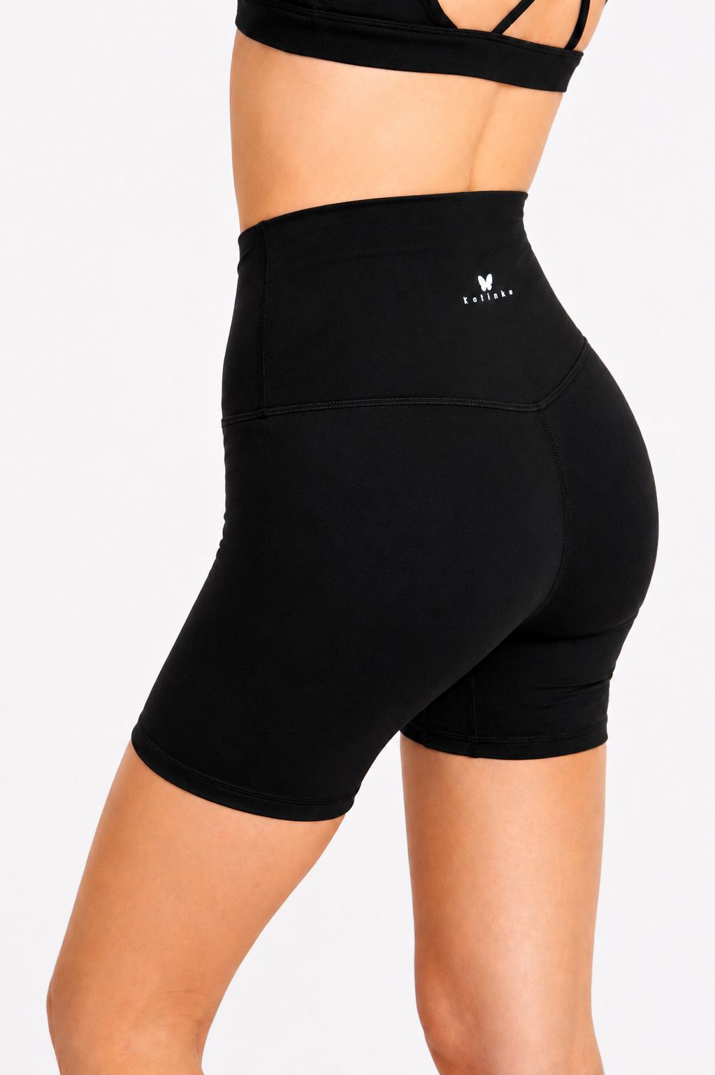Black athletic shorts worn by a person on a white background